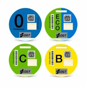 Conjunto de las cuatro pegatinas oficiales de distintivos ambientales de la DGT para vehículos: 0 Emisiones (azul), ECO (verde y azul), C (verde) y B (amarilla).
